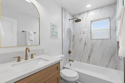 a white bathroom with a sink and a toilet at One Block to Beach 4BR Game Room and Parking in San Diego