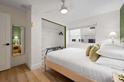 a bedroom with a large white bed and a mirror at Explore South Park from 2-Story Home Sleeps 8 in San Diego