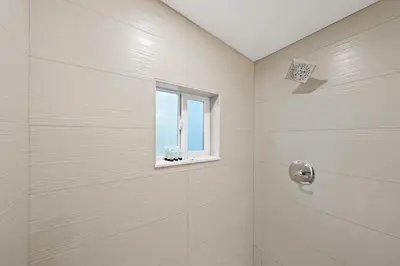 a bathroom with a shower with a window at Explore South Park from 2-Story Home Sleeps 8 in San Diego