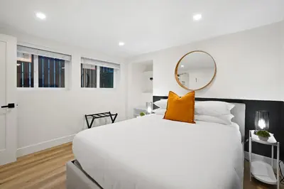 a bedroom with a large white bed and a mirror at Explore South Park from 2-Story Home Sleeps 8 in San Diego