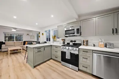 a kitchen with stainless steel appliances and a living room at Explore South Park from 2-Story Home Sleeps 8 in San Diego