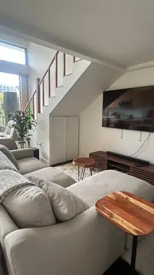 a living room with a couch and a staircase at Loft on 6th and Market in San Diego