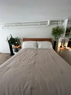 a bedroom with a large bed with white sheets at Loft on 6th and Market in San Diego