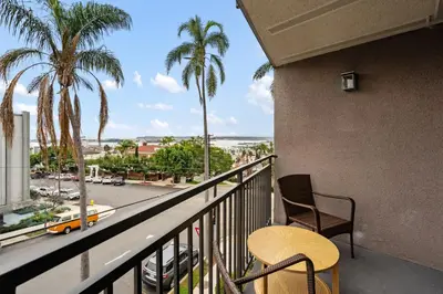 a balcony with a table and chairs and palm trees at Bay View Penthauz Monthly Rental 2 parking spots in San Diego