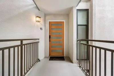 a hallway with a door and a clock on the wall at Bay View Penthauz Monthly Rental 2 parking spots in San Diego