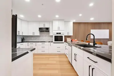 a kitchen with white cabinets and stainless steel appliances at Bay View Penthauz Monthly Rental 2 parking spots in San Diego