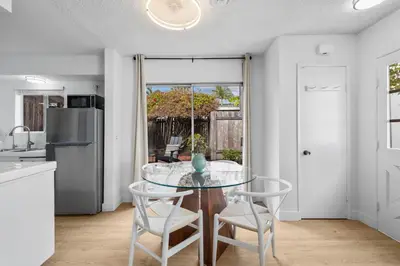 a kitchen and dining room with a glass table and chairs at Steps to Windnsea Beach | Parking, Patio, Location! in San Diego