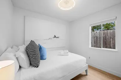 a white bedroom with a white couch and a window at Steps to Windnsea Beach | Parking, Patio, Location! in San Diego