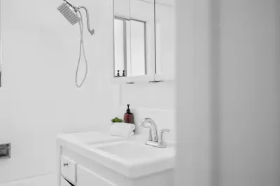 a white bathroom with a sink and a mirror at Steps to Windnsea Beach | Parking, Patio, Location! in San Diego