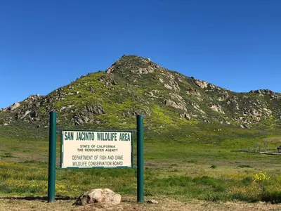 a sign in a field with a mountain in the background at Sleeps 12 - Hot Tub - Pool - Game Room & Fire Pit! in Hemet