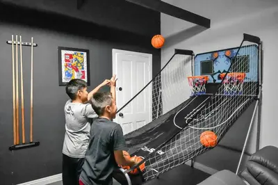 two young men playing a game of basketball at Sleeps 12 - Hot Tub - Pool - Game Room & Fire Pit! in Hemet