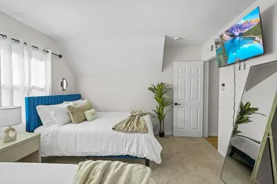 a bedroom with a bed and a tv on a wall at Sleeps 12 - Hot Tub - Pool - Game Room & Fire Pit! in Hemet