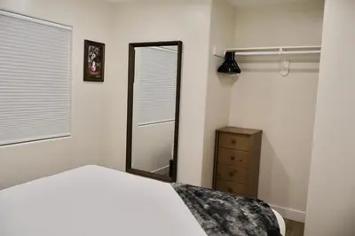 a bedroom with a mirror and a bed and a dresser at 2 Masters, Newly renovated with new furnishings - 4BR 3BA in San Diego