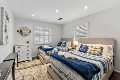 a bedroom with two beds and a dresser at Bungalow Downtown Easy Airport Access Family Friendly in San Diego