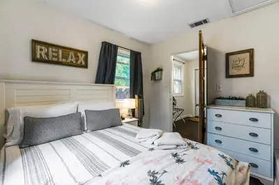a bedroom with a large bed and a dresser at Bungalow Downtown Easy Airport Access Family Friendly in San Diego