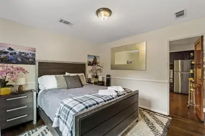 a bedroom with a bed and a refrigerator at Bungalow Downtown Easy Airport Access Family Friendly in San Diego