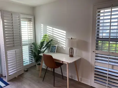 a white room with a table and a chair and windows at Spanish Style San Diego Home Near Beaches in San Diego