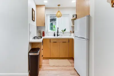 a kitchen with wooden cabinets and a white refrigerator at Sip, Golf and Unwind Couples Retreat in Fallbrook in Fallbrook