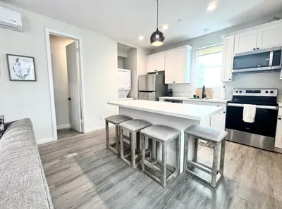 a kitchen with a white counter and bar stools at Central SD Townhome 2 King Beds Zoo DT North Park in San Diego