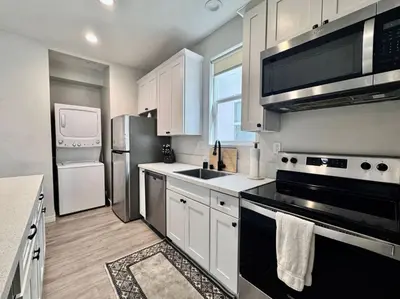 a kitchen with white cabinets and stainless steel appliances at Central SD Townhome 2 King Beds Zoo DT North Park in San Diego
