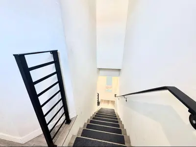 a staircase in a building with a black railing at Central SD Townhome 2 King Beds Zoo DT North Park in San Diego