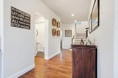 a room with a hallway with a staircase and a table at Quiet Carlsbad Home One and a Half Miles from the Beach in Carlsbad