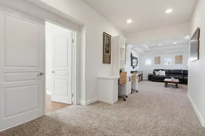 a white hallway with a door and a living room at Quiet Carlsbad Home One and a Half Miles from the Beach in Carlsbad