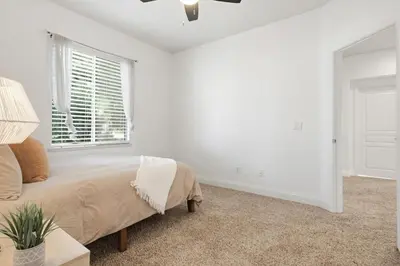 a white bedroom with a bed and a window at Quiet Carlsbad Home One and a Half Miles from the Beach in Carlsbad