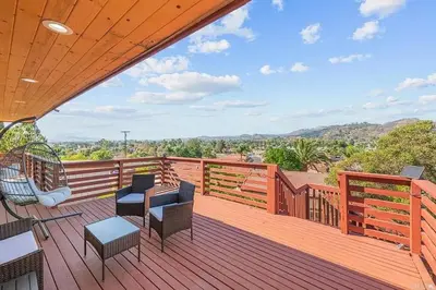 a wooden deck with chairs and tables on it at Mountains Views with Pool & Basketball, Relax & Play! in Escondido