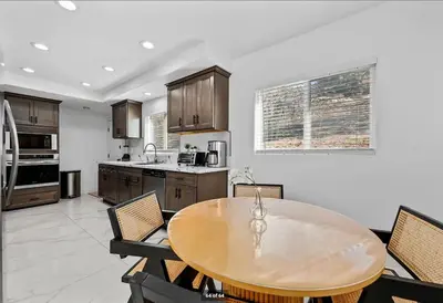 a kitchen with a wooden table and some chairs at Mountains Views with Pool & Basketball, Relax & Play! in Escondido