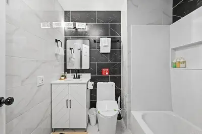a bathroom with a toilet and a sink and a mirror at Mountains Views with Pool & Basketball, Relax & Play! in Escondido