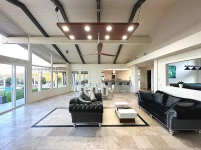 a living room with black leather furniture and a ceiling at Private Pickleball Villa, Pool Oasis & Chic Casita in Fallbrook