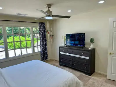 a bedroom with a bed and a flat screen tv at Private Pickleball Villa, Pool Oasis & Chic Casita in Fallbrook