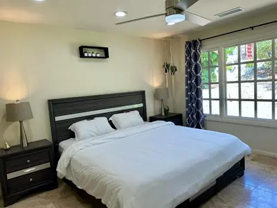 a bedroom with a large bed with white sheets at Private Pickleball Villa, Pool Oasis & Chic Casita in Fallbrook