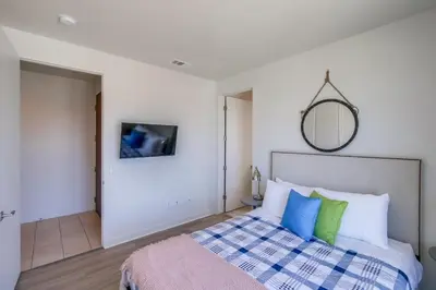 a bedroom with a bed with blue and green pillows at Ocean Park Combo 9 & 10 in San Diego