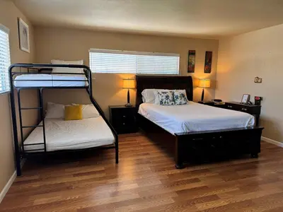 a bedroom with two bunk beds and a wooden floor at Mina Home in San Diego