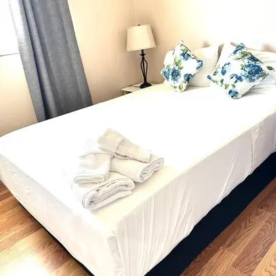 a bed with towels and pillows on it at Mina Home in San Diego