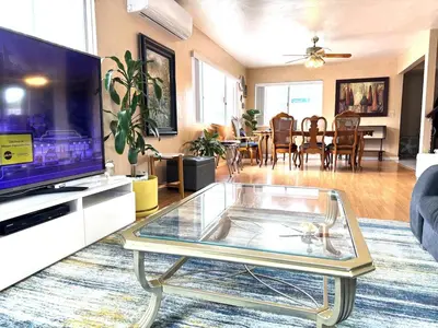 a living room with a tv and a glass coffee table at Mina Home in San Diego