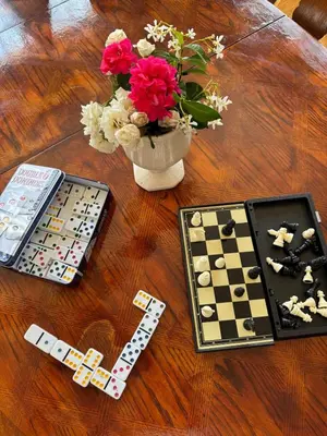 a table with a vase of flowers and a game at Mina Home in San Diego