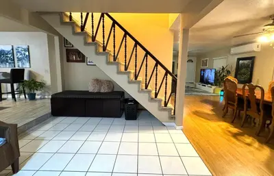 a living room with a staircase in a house at Mina Home in San Diego