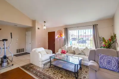 a living room with a white couch and a glass table at Entire Private Home with 4 Bedrooms - 3 Bathrooms, Big Yard, Garage, King Bed, Crib, Available Now in San Diego