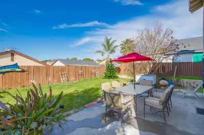 a patio with a table and chairs and an umbrella at Entire Private Home with 4 Bedrooms - 3 Bathrooms, Big Yard, Garage, King Bed, Crib, Available Now in San Diego