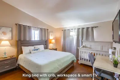 a bedroom with a bed with a crib and a desk at Entire Private Home with 4 Bedrooms - 3 Bathrooms, Big Yard, Garage, King Bed, Crib, Available Now in San Diego