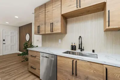 a kitchen with wooden cabinets and a stainless steel sink at Palm Haven Retreat Cozy 2BR Near Downtown in San Diego