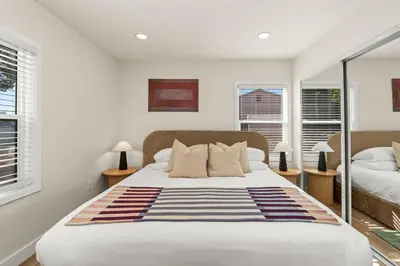 a bedroom with a large bed and two windows at Palm Haven Retreat Cozy 2BR Near Downtown in San Diego