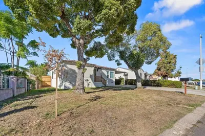a yard with two trees in front of a house at Palm Haven Retreat Cozy 2BR Near Downtown in San Diego
