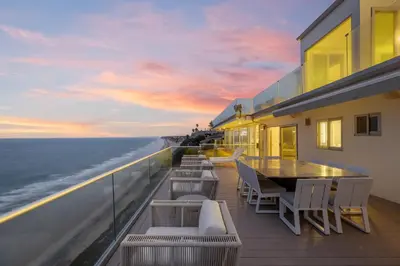 a balcony with a table and chairs and the ocean at Encinitas Shores - Beachfront, Ocean View & Patio in Encinitas