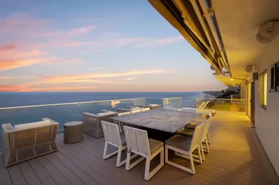 a balcony with a table and chairs and the ocean at Encinitas Shores - Beachfront, Ocean View & Patio in Encinitas