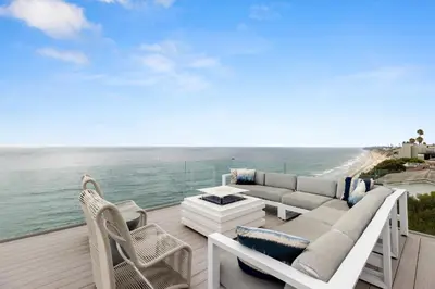 a patio with a couch and chairs and the ocean at Encinitas Shores - Beachfront, Ocean View & Patio in Encinitas