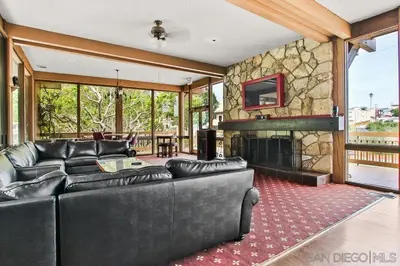 a living room with leather furniture and a stone fireplace at Luxury Condo Resort Amenities - Pool, Pickleball in San Diego